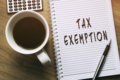 tax exemption on notebook with coffee cup next to it