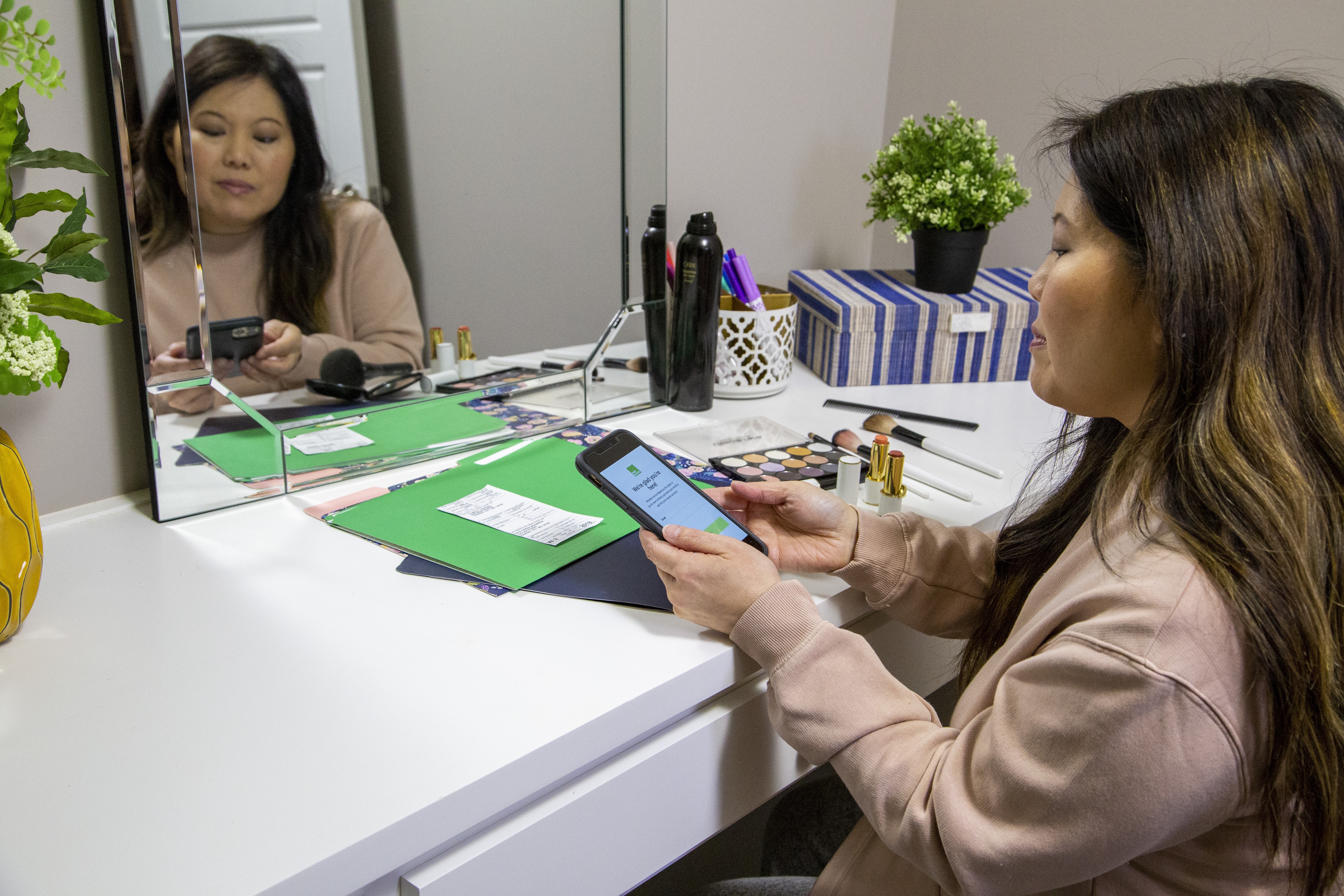 Woman sitting at a vanity filing her taxes with H&R Block Tax Pro Go.