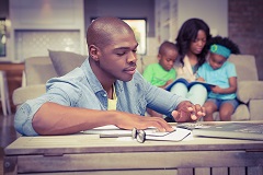 Man reviewing lookback rule with family in background.